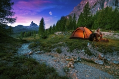 Mystical night landscape, in the foreground hike, campfire and tent